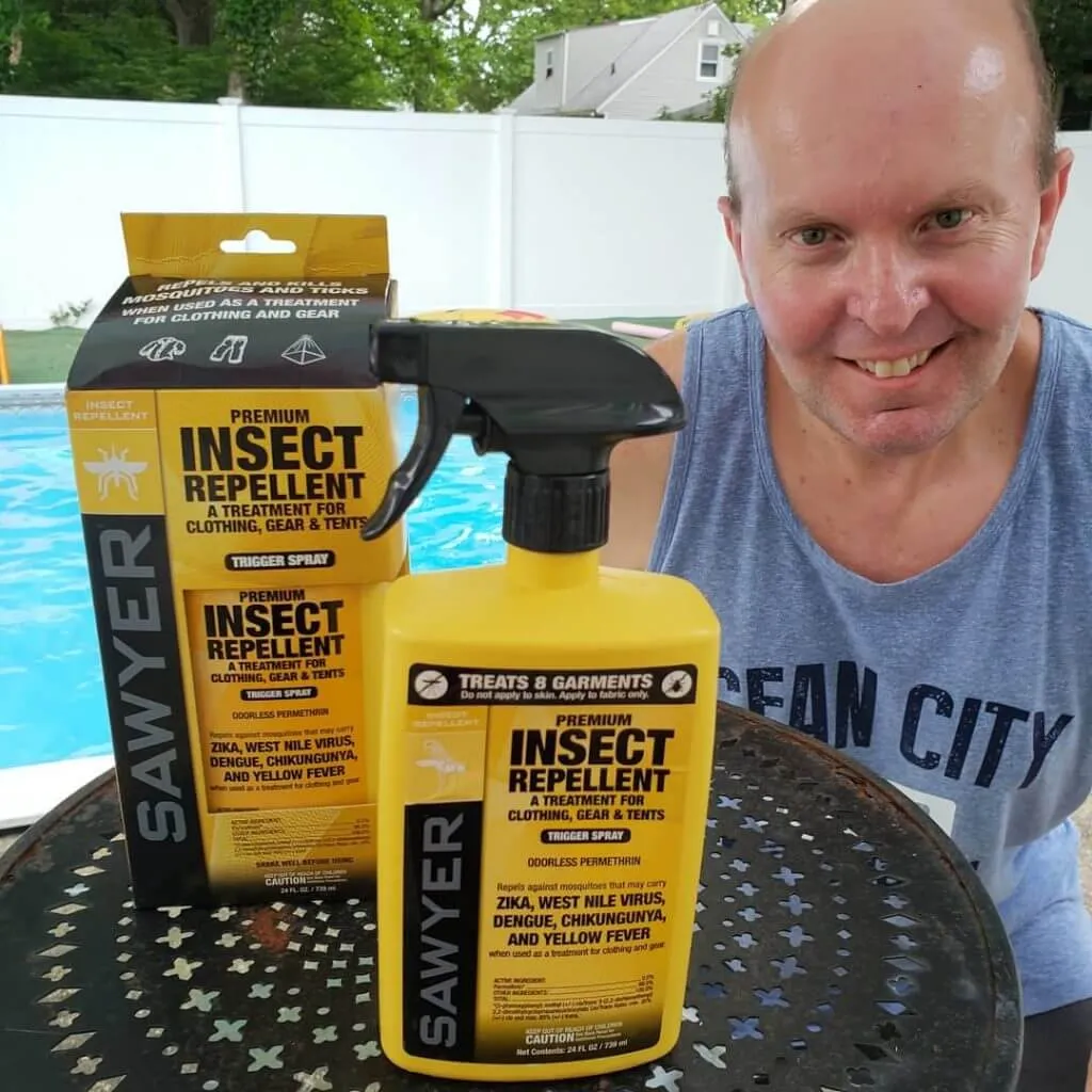 man poses next to sawyer premium insect repellent
